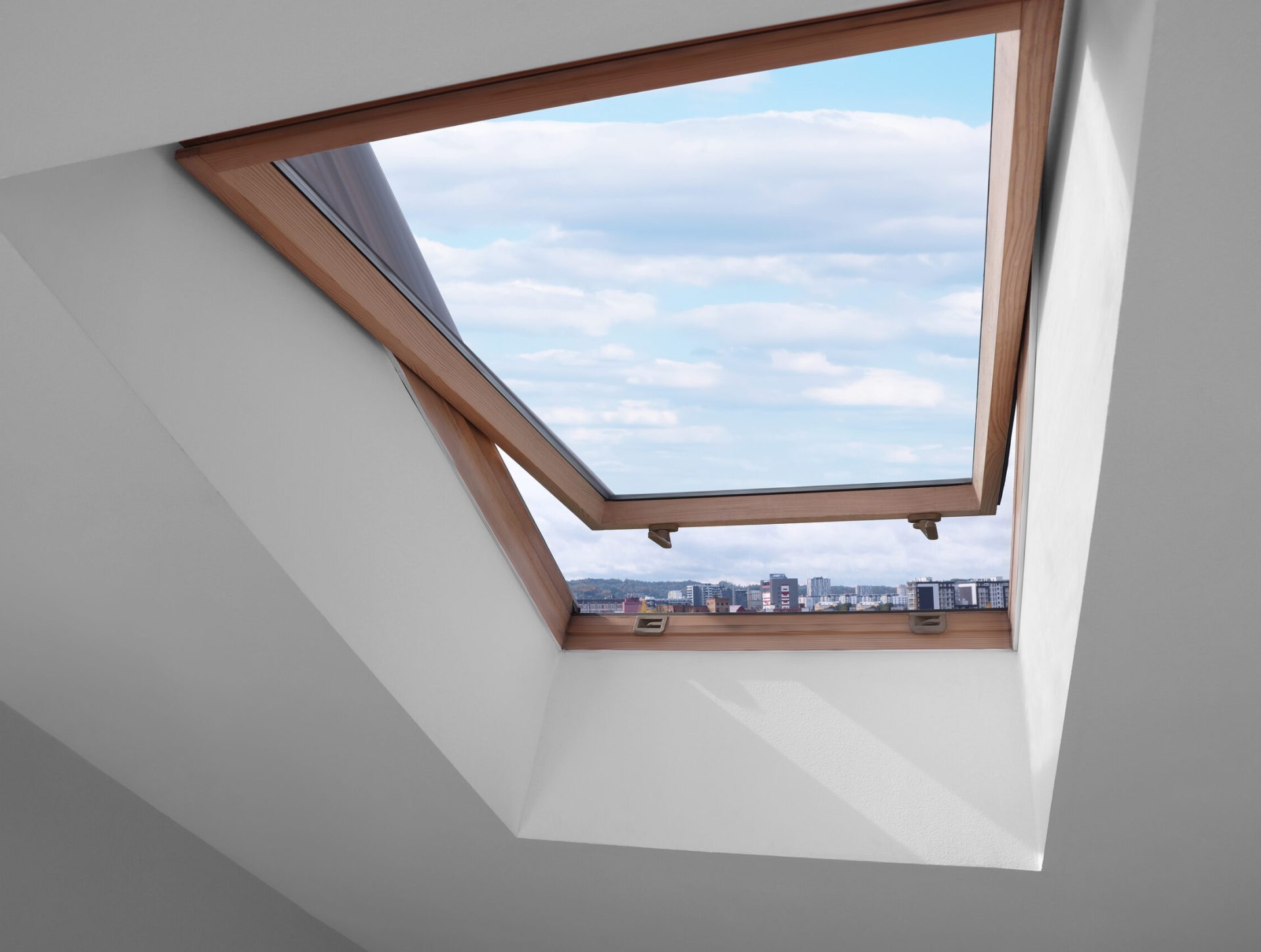 Open skylight roof window on slanted ceiling in attic room