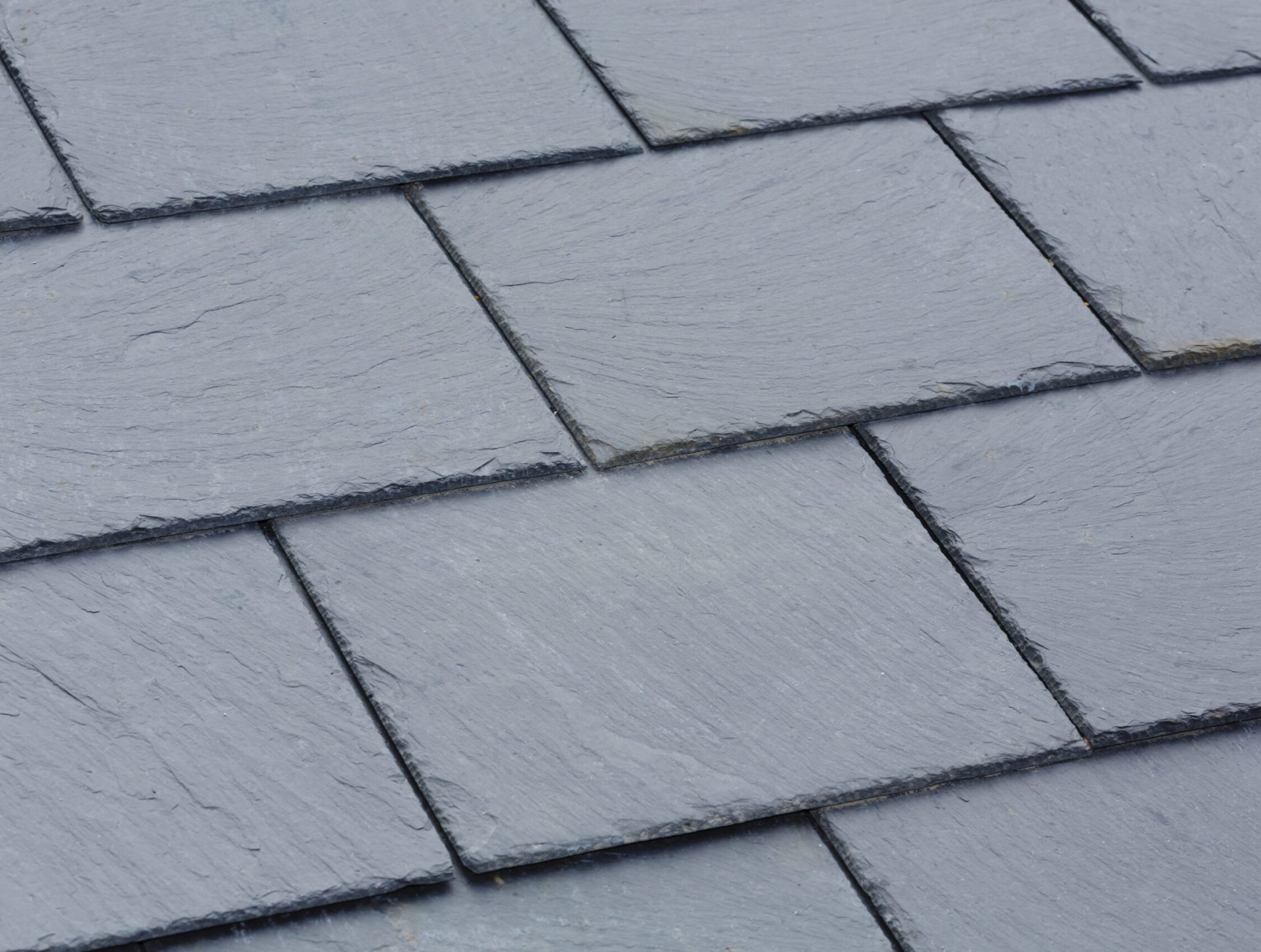 Closeup of traditional grey slate roof tiles on a pitched roof